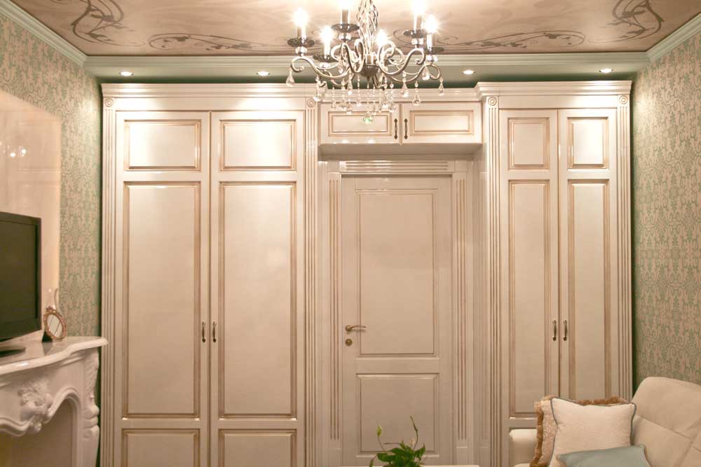 Белый платяной шкаф в классической гостиной. Фото