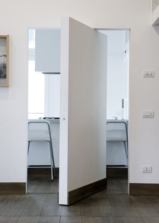 Потайная межкомнатная дверь без ручек в минималистичной тотально белой квартире