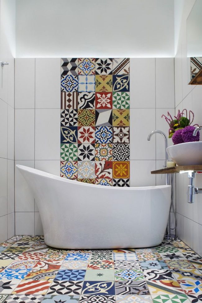 Панно из разноцветной плитки поддерживается такой же плиткой на полу ванной комнаты