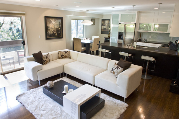 Фото: зонирование угловым диваном пространства комнаты, сочетающей в себе гостиную и кухню