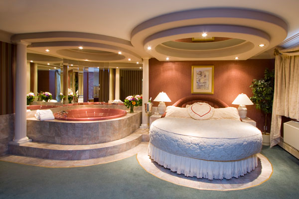 Круглая кровать в спальне с ванной