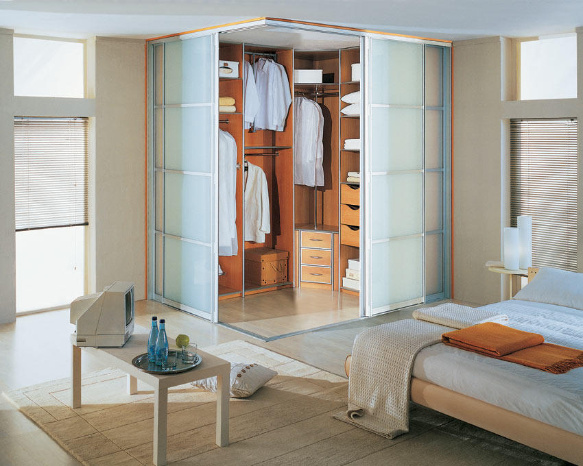 Стильная угловая гардеробная с прозрачными дверцами прекрасно впишется в интерьер небольшой спальни