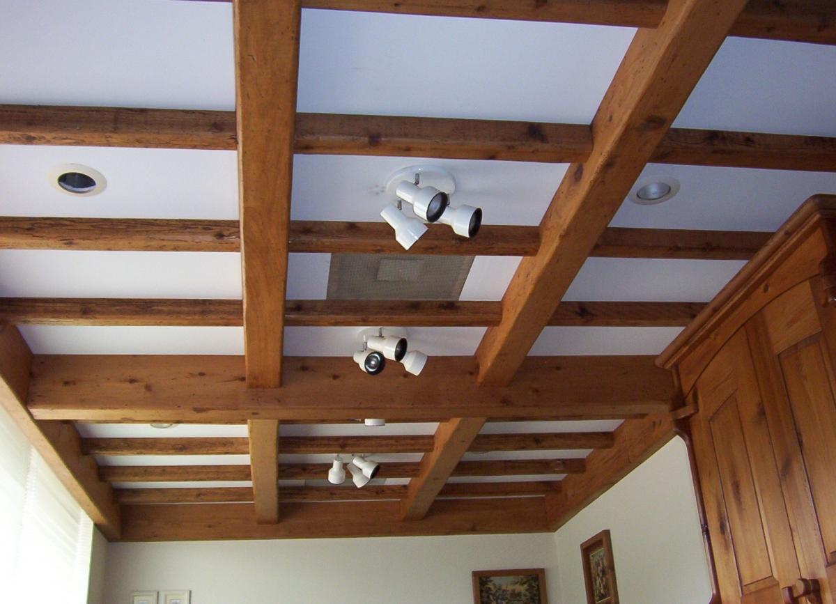Популярными являются и натяжные потолки со стилизованными перекрытиями в виде балок