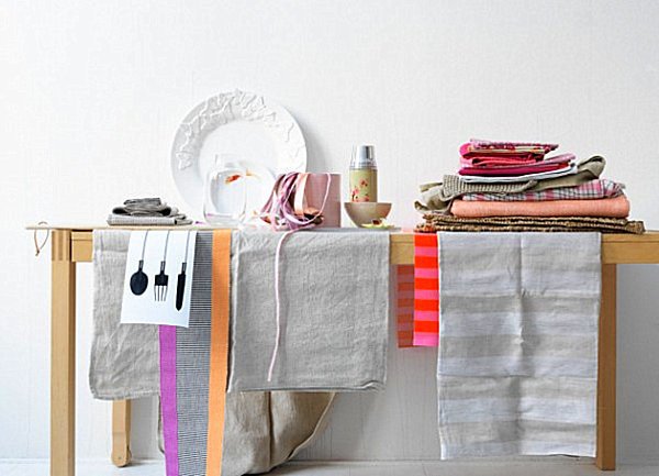 Разноцветные кухонные полотенца и тканевые салфетки на деревянном столике
