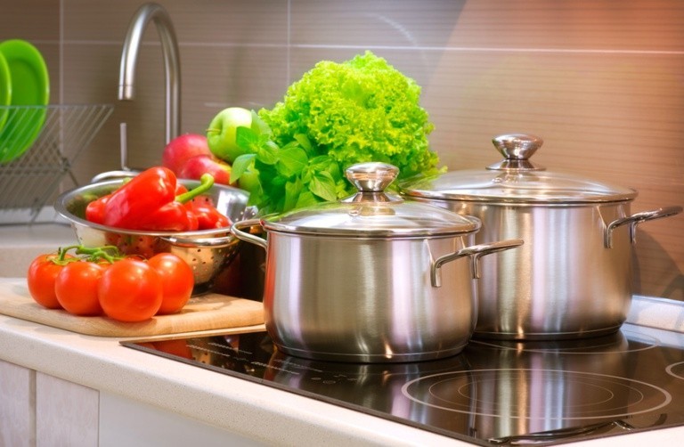 Кухонная плита, кастрюли, овощи и зелень