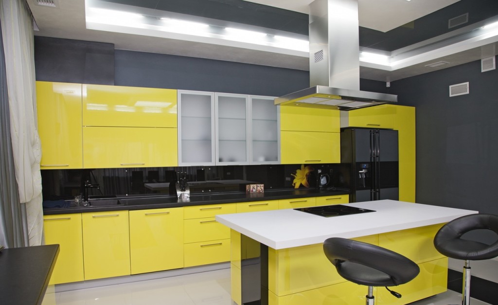 Кухня с глянцевыми жёлтыми фасадами и чёрным фартуком