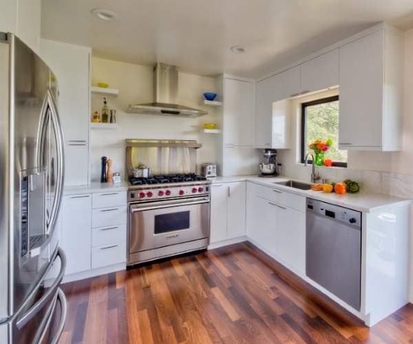 Белая угловая кухня - фото в интерьере с деревянным полом