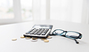 Калькулятор, очки и монеты на офисным столом | Фото