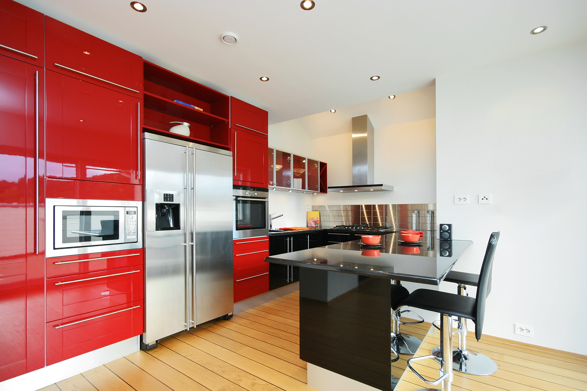 Красный кухонный гарнитур с черной и металлической мебелью на кухне