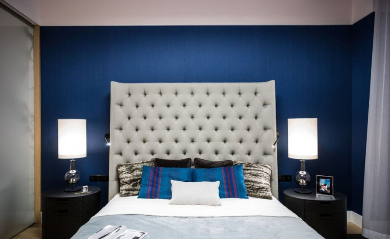 Синяя стена и подушки в спальне