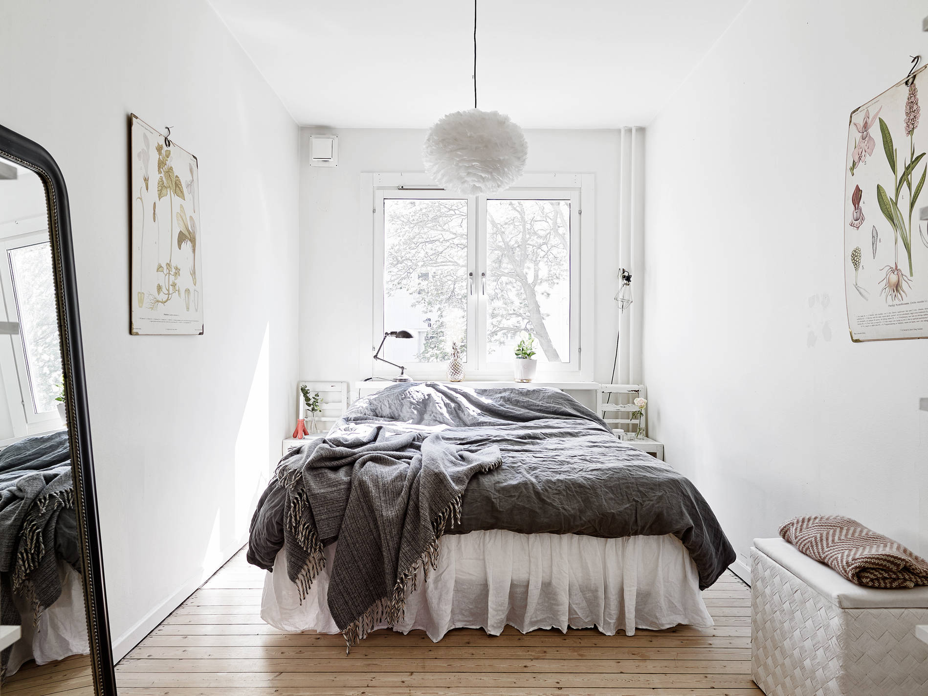 Кровать изголовьем к окну в спальне в скандинавском стиле