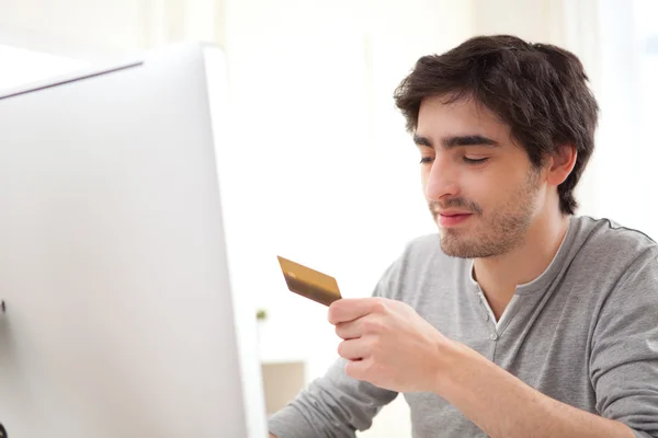 Молодой человек спокойно, оплаты онлайн с помощью кредитной карты — стоковое фото