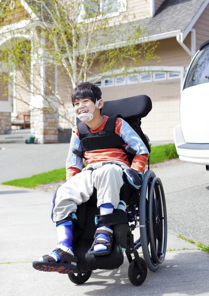 Счастливый мало инвалидов мальчик в инвалидной коляске — стоковое фото
