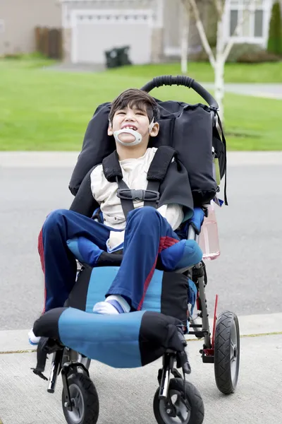 Счастливый мало инвалидов мальчик в инвалидной коляске — стоковое фото