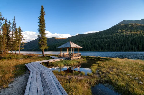 Деревянный дощатый вдоль озера в горах — стоковое фото