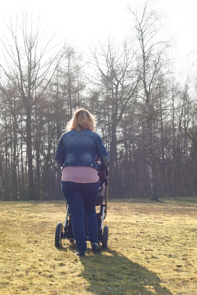 Мать ходит с коляской — стоковое фото