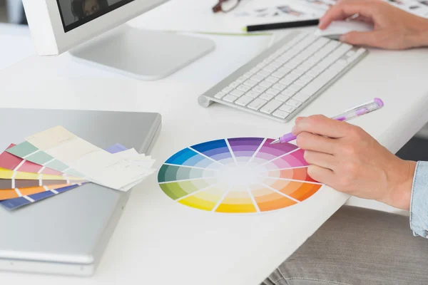 Дизайнер, работающий на ее регистрации, с помощью цветовой круг — стоковое фото