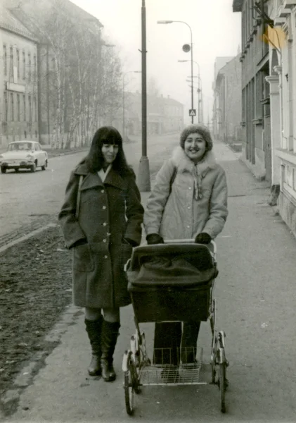 Друзья - две молодые женщины с прогулочная коляска — стоковое фото