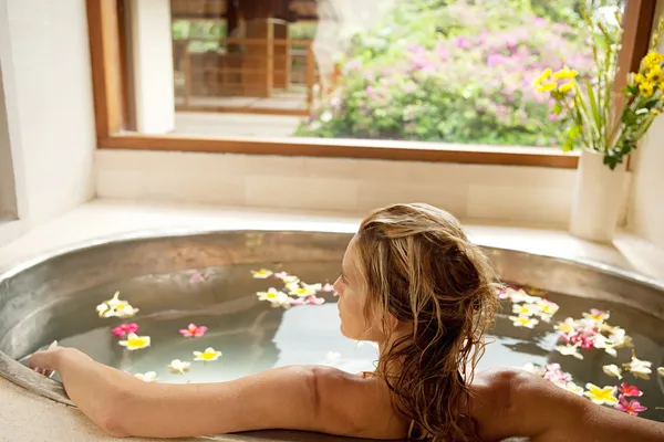 Вид сзади молодой женщины, купание в ванне спа цветок — стоковое фото