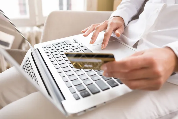 Крупным планом женские руки проведения кредитной карты и с помощью компьютера — стоковое фото