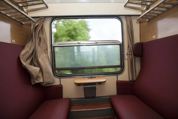 Отделение поезда с красными местами и представлением из окна — стоковое фото