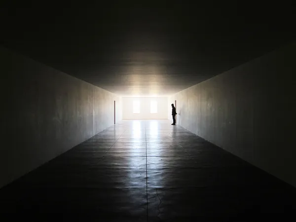 Человек, стоящий в темной комнате — стоковое фото