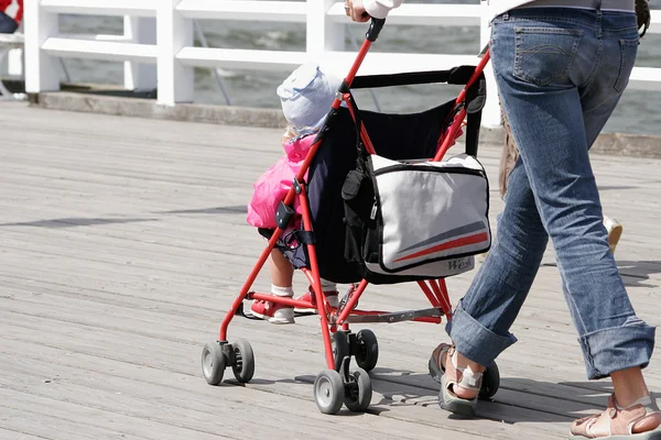 Мать с ребенком в коляске ходьба — стоковое фото