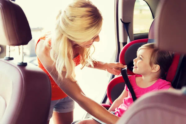 Счастливая мать крепления ребенка с автомобильный ремень — стоковое фото