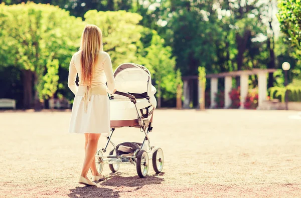 Счастливая мать с коляски в парке — стоковое фото
