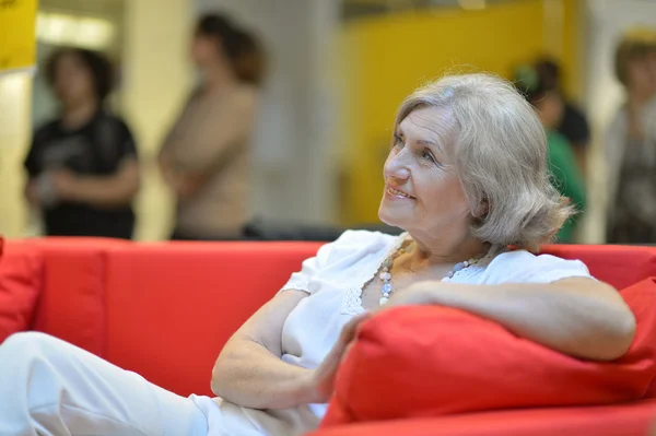 Пожилая женщина, сидящая в диван — стоковое фото