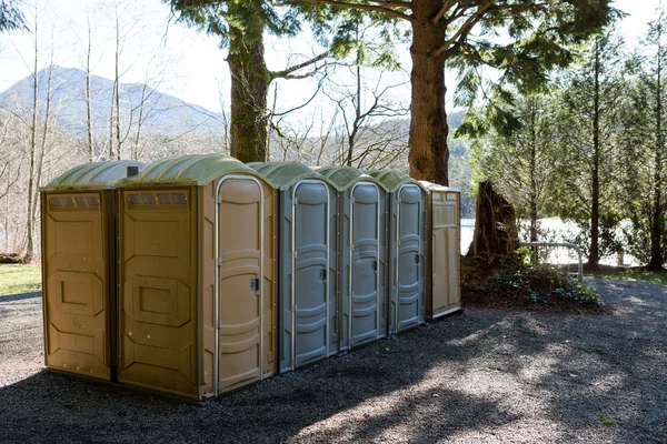 Ряд общественных туалетов Portapotty в парке — стоковое фото