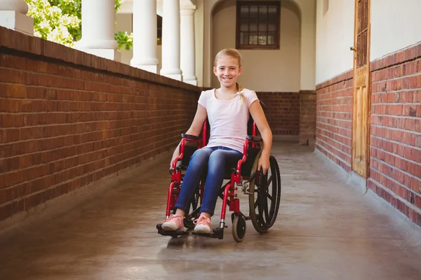 Девочка сидит в инвалидном кресле в школьный коридор — стоковое фото