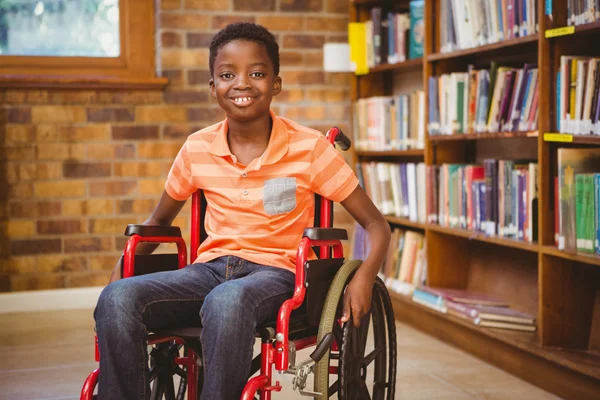 Портрет мальчика, сидя в инвалидном кресле в библиотеке — стоковое фото