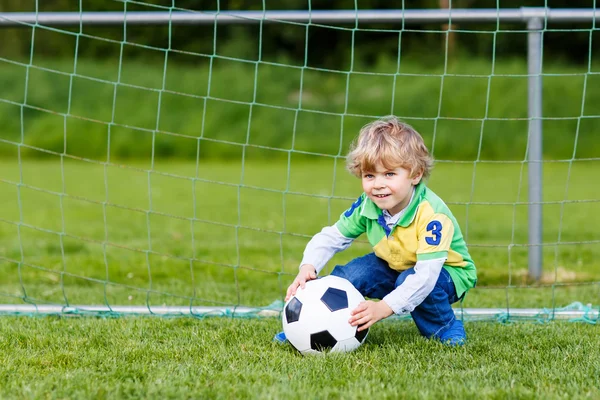 Два маленький брат мальчиков, игры футбол и футбол на поле — стоковое фото