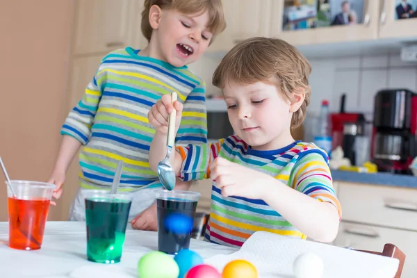 Два маленький белокурый ребенок мальчиков раскраски яйца на Пасху — стоковое фото