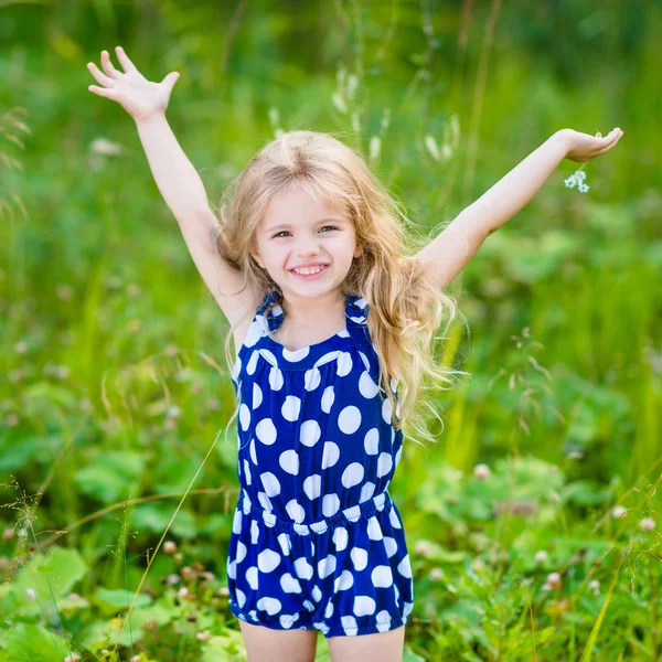 Улыбающаяся маленькая девочка с длинными светлыми вьющимися волосами — стоковое фото