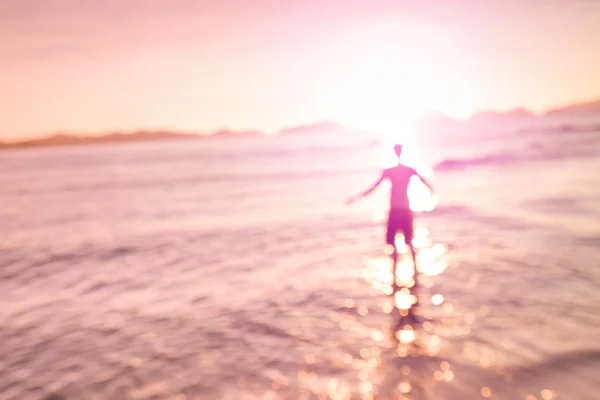 Помутнение расфокусированным силуэт человека, стоящего на берегу моря с наклонным горизонтом - Концепция свободы и страсть к путешествиям с человека в воде на пляже Лас Кабанаш в Эль Нидо - Розовый кварц фильтруется взгляд — стоковое фото