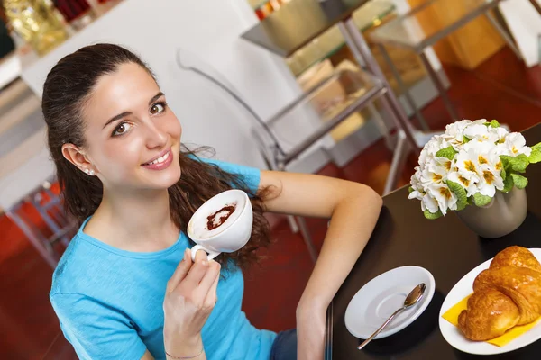 Девушка с кофе-брейк с капучино в форме сердца — стоковое фото