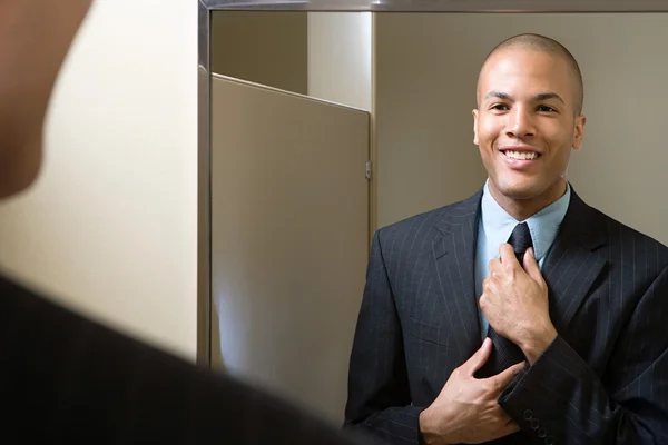Регулировочный галстук человек в зеркале — стоковое фото