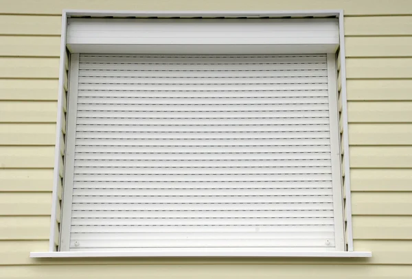 Окно с белым внешним домом жалюзи — стоковое фото