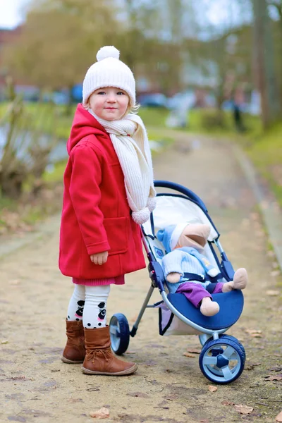 Маленькая девочка, ходьба с прогулочной коляски в парке — стоковое фото