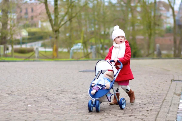 Маленькая девочка, ходьба с прогулочной коляски в парке — стоковое фото