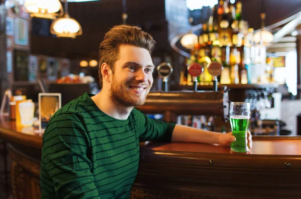 Мужчина пьет зеленого пива в баре или пабе — стоковое фото