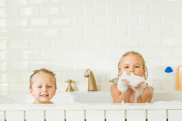 Дети играют в ванной с пеной — стоковое фото