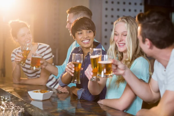 Друзья, поджаривания бокал пива в барной стойкой — стоковое фото