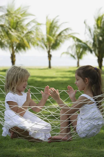 Две девочки играют в гамаке — стоковое фото