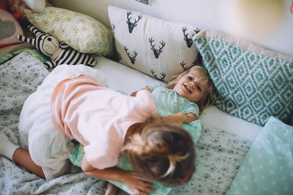 Маленькие сестры весело с подушками — стоковое фото