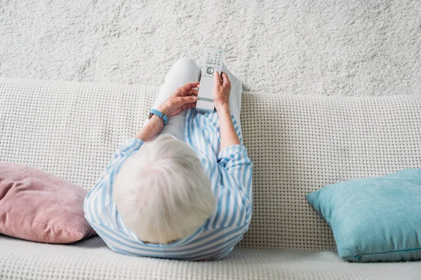 Overhead View Senior Woman Remote Control Watching Sofa Home — стоковое фото