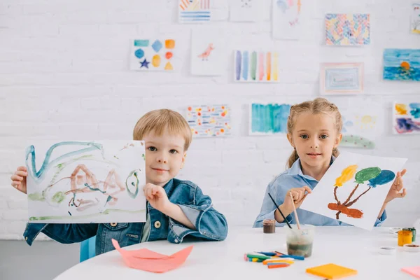 Portrait Cute Kids Showing Drawings Hands Table Classroom — стоковое фото