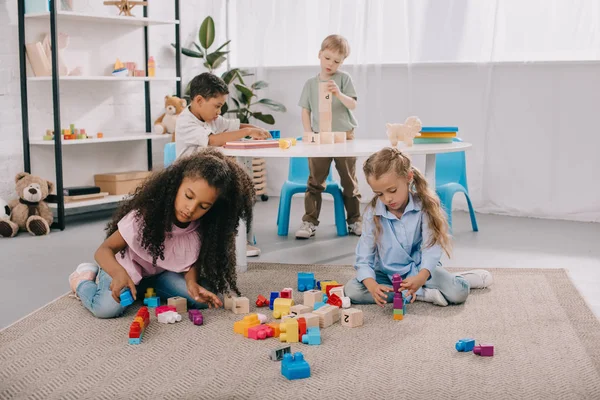Focused Multiracial Preschoolers Playing Wooden Blocks Classroom — стоковое фото